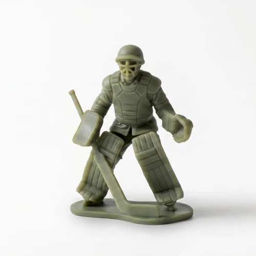green resin figurine of a WWII-style soldier wearing an M1 helmet and field jacket layered with vintage hockey goalie pads, holding a goalie stick and catching glove,
