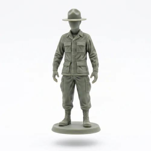 Precise, clean 3/4 profile photograph of a smooth, unpainted grey-green soldier figurine with a campaign hat, centered on a pure white background with a soft, diffuse grounding shadow.